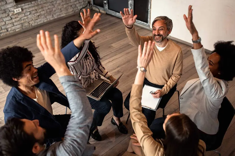 Grupo de personas levantando la mano en una sesión de clase