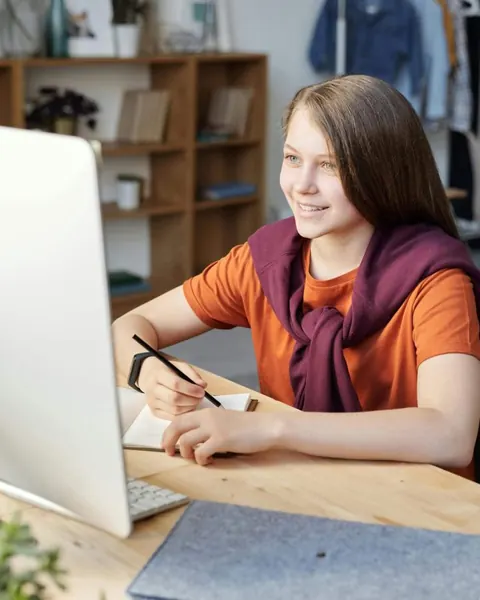 Estudiante trabajando con su computadora en una sala de estudio